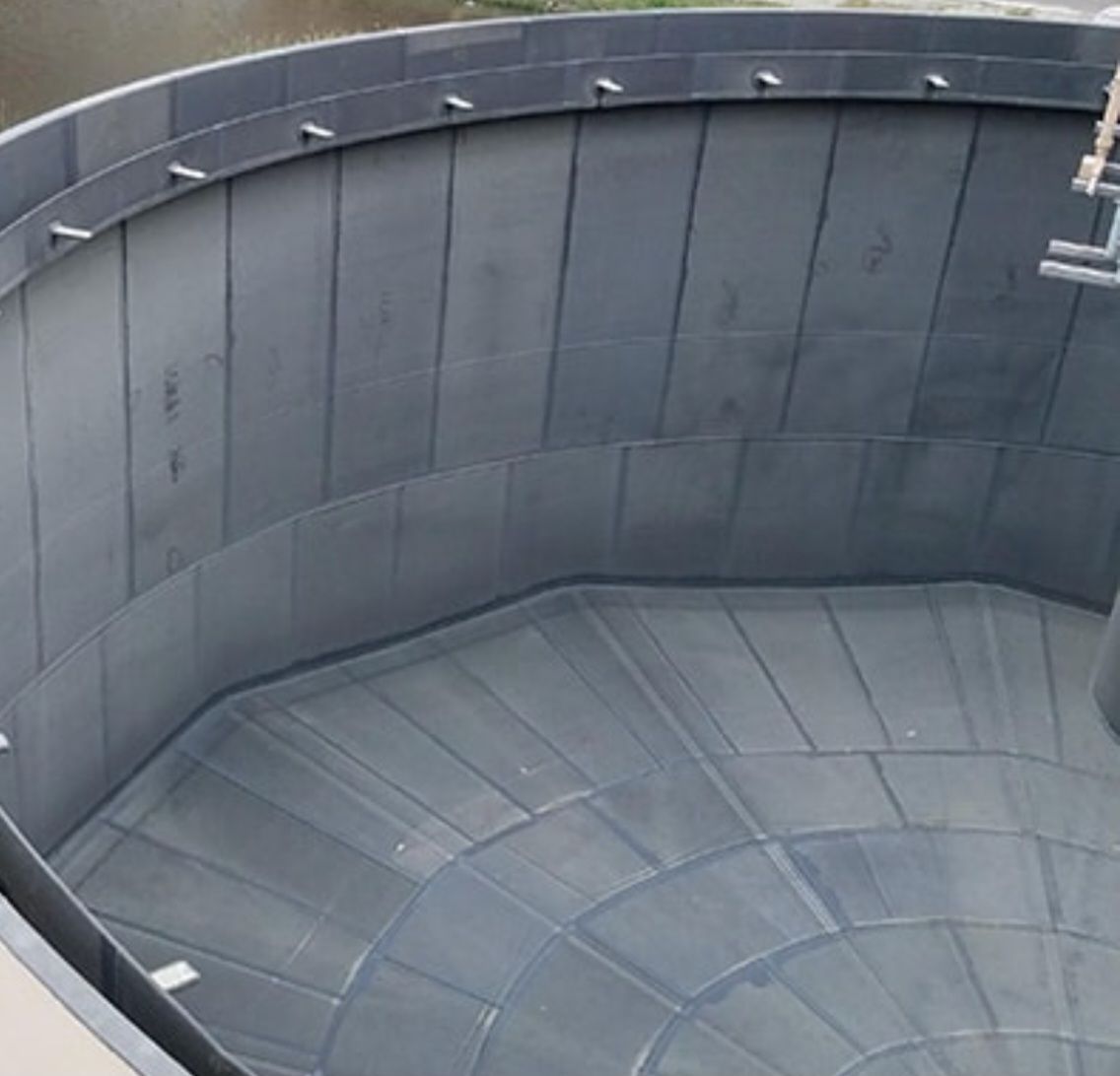 Interior view of a rubber-lined tank showing seamed panel lining